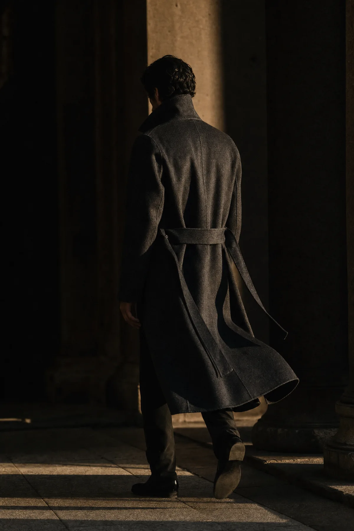 A charcoal cashmere overcoat in motion.